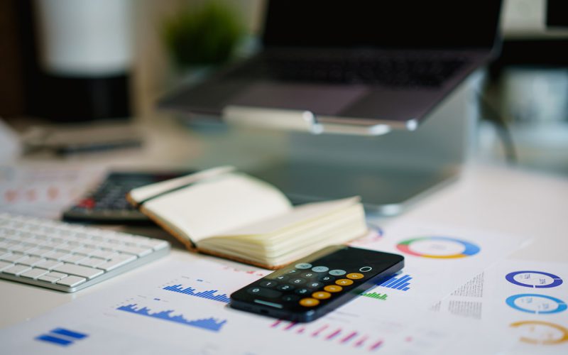 office desk with smartphone and financial charts