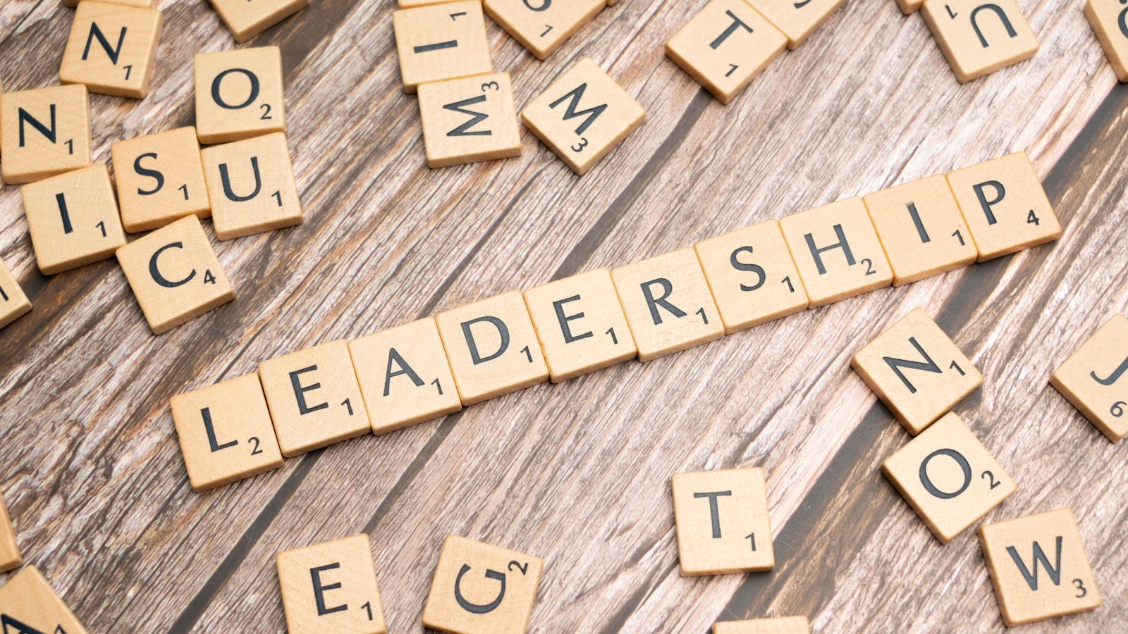 scrabble tiles spelling out the word leadership on a wooden surface