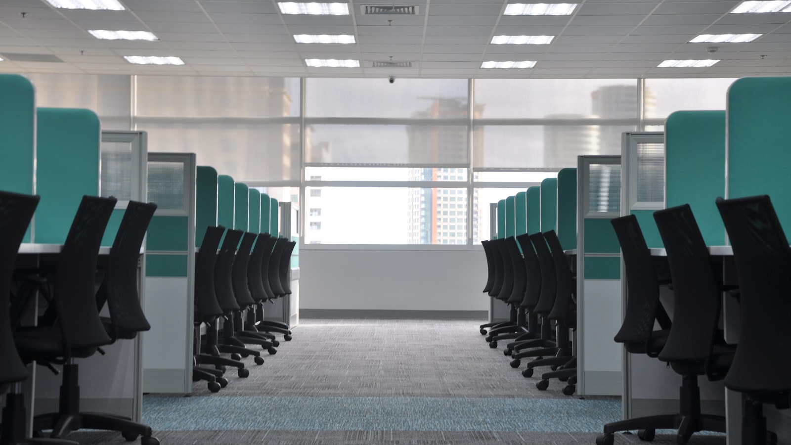 empty black rolling chairs at cubicles