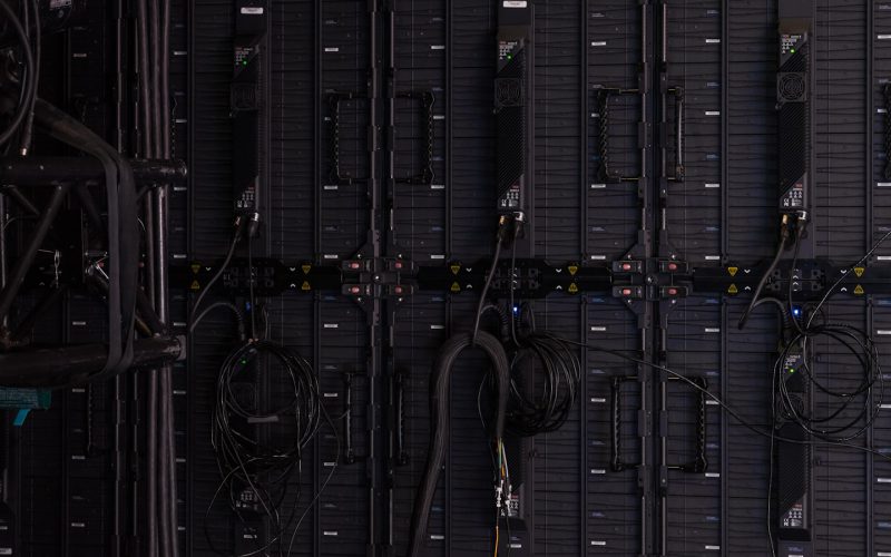Black cables and wires connected to the back of modular LED display panels