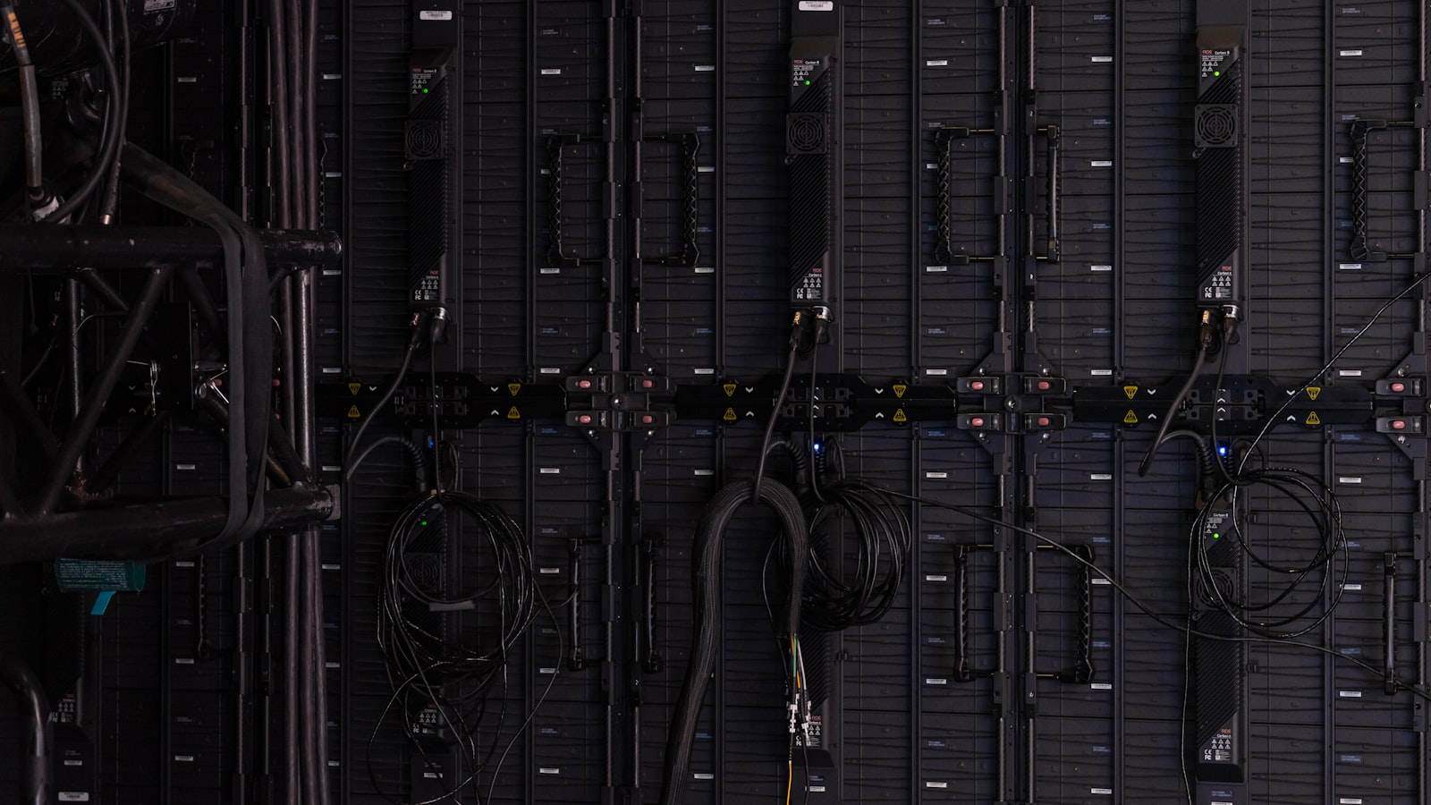 Black cables and wires connected to the back of modular LED display panels