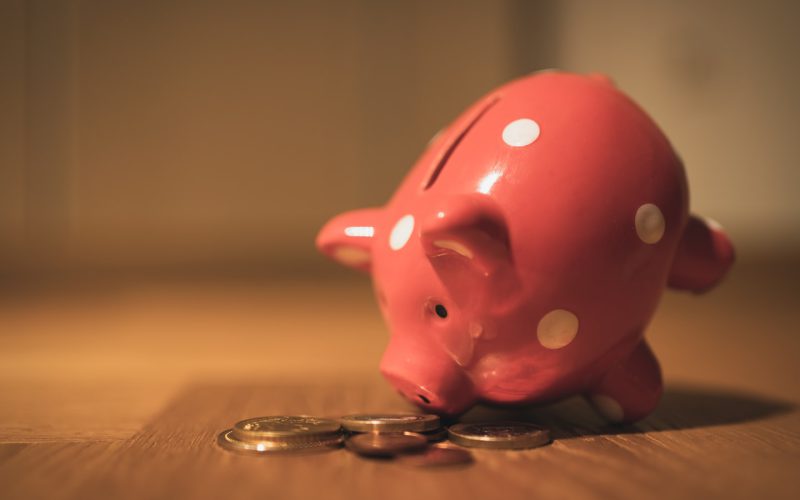pink pig coin bank on brown wooden table