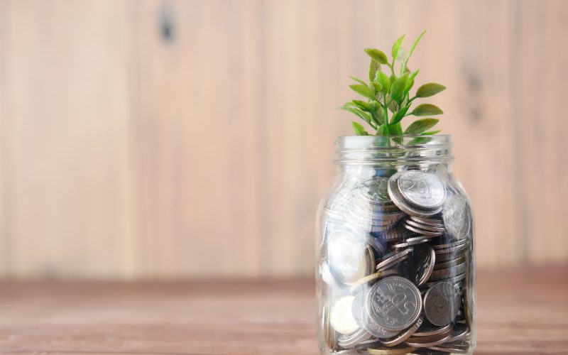 a glass jar filled with coins and a plant