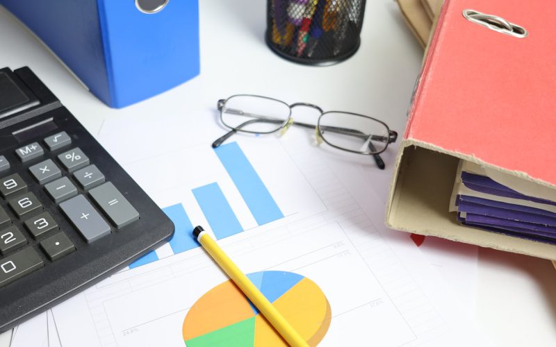 Desk with calculator, charts, and binders