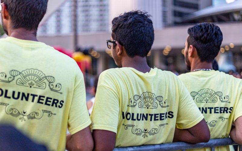 three men wearing yellow Volunteers shirts