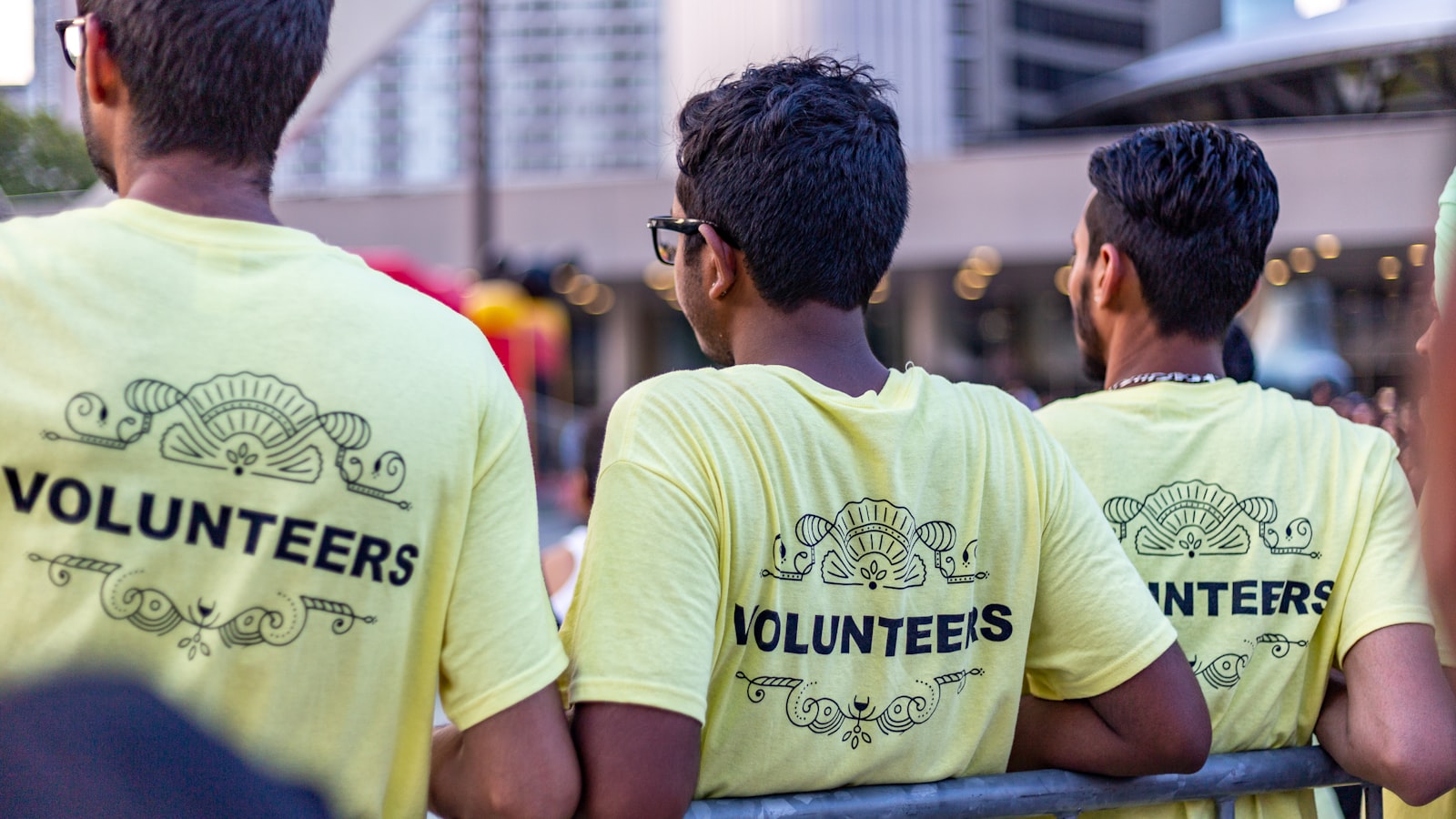 three men wearing yellow Volunteers shirts
