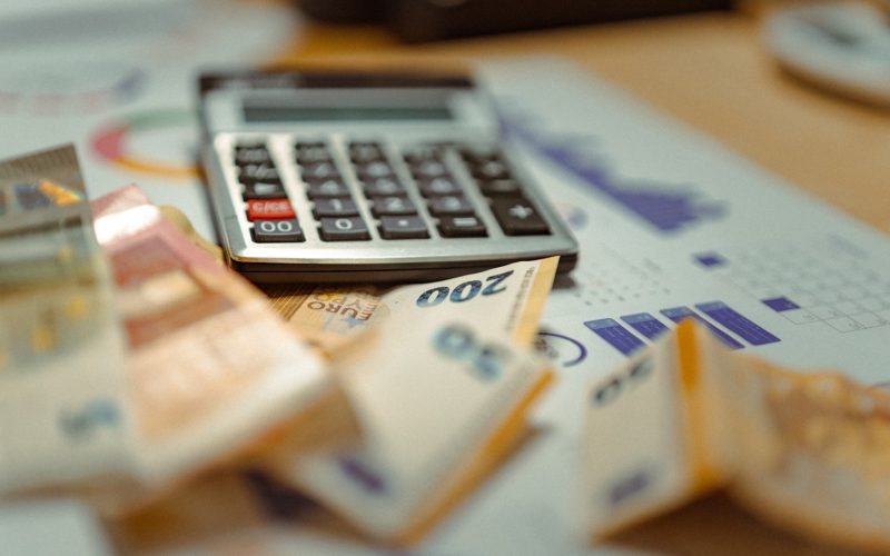 A calculator sitting on top of a pile of money