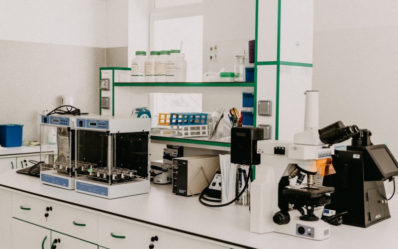 A laboratory workbench with a microscope and analytical equipment in a bright room
