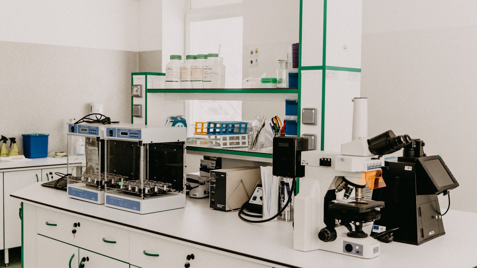 A laboratory workbench with a microscope and analytical equipment in a bright room